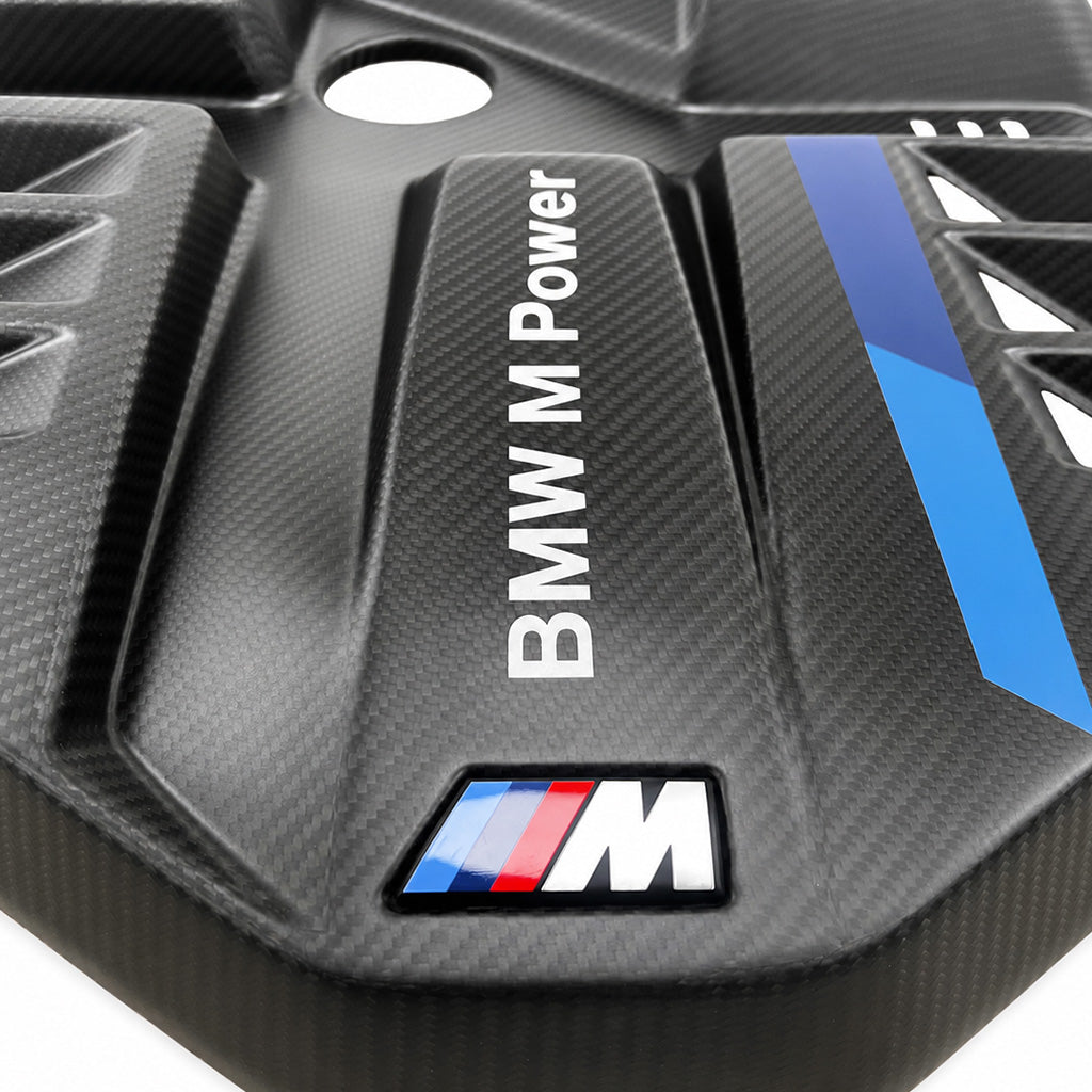 Detail of BMW G8X S58 EVE carbon fiber engine cover with BMW M Power lettering, M badge and deep angular cooling scoops