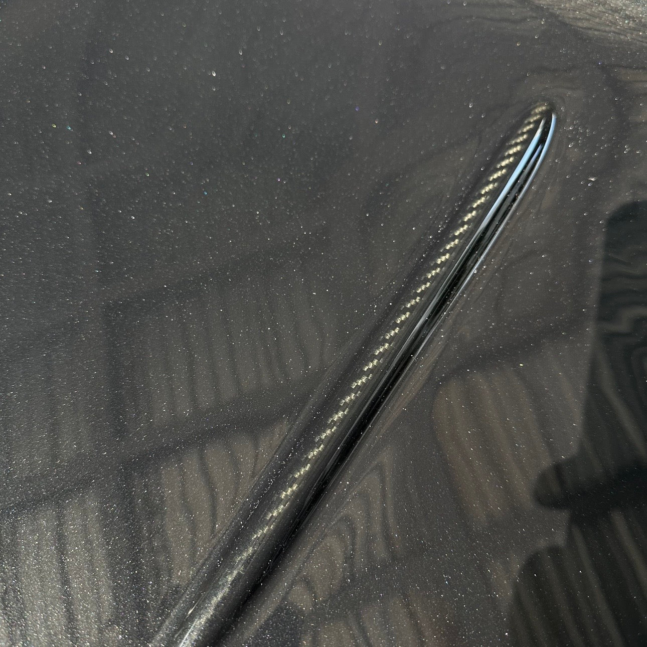 BMW G87 M2 CS carbon fiber trunk lid with a raised character line left in exposed carbon against body paint, a carbon accent line finish