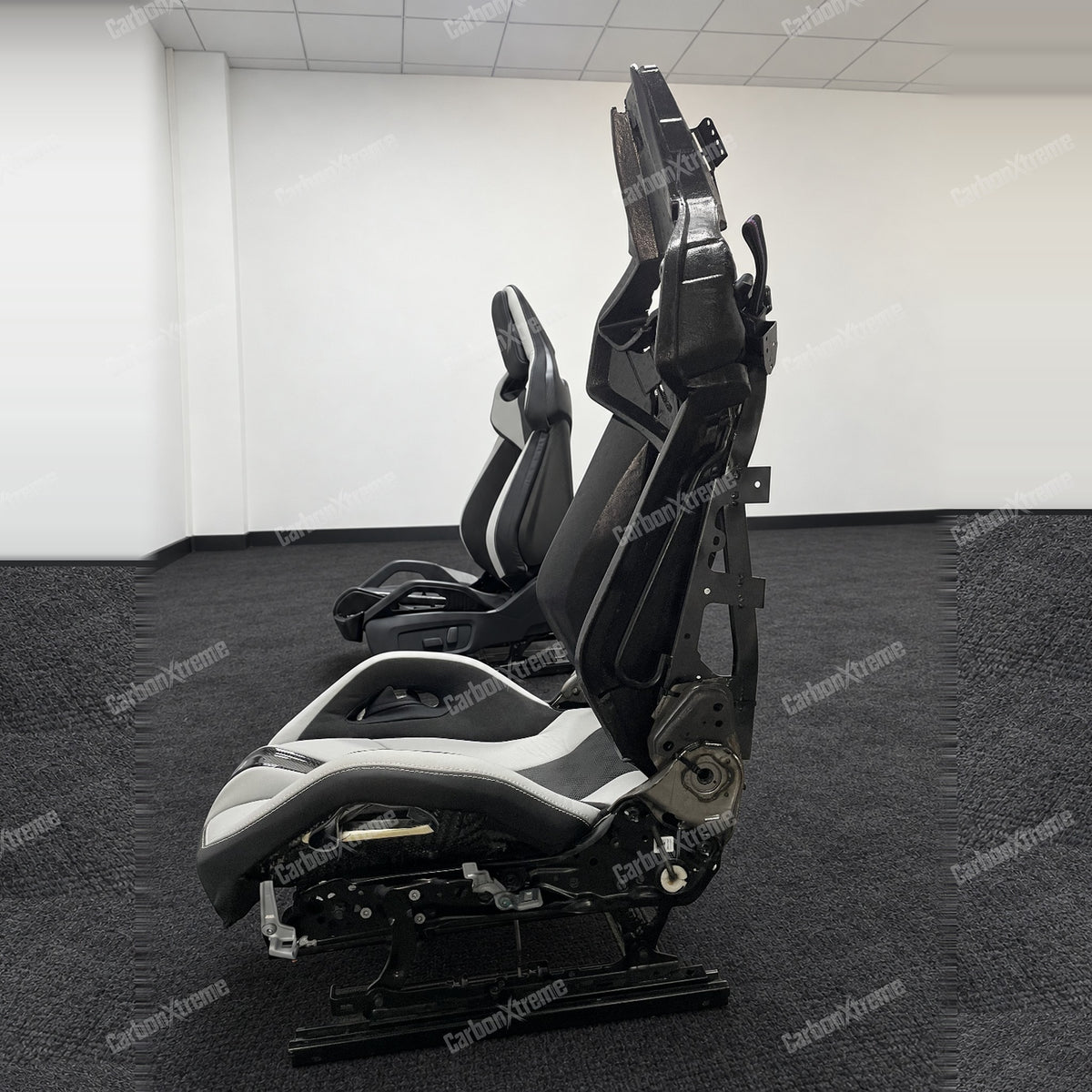 BMW M carbon fiber bucket seat, side profile showing the seat frame, rails and adjustment hardware
