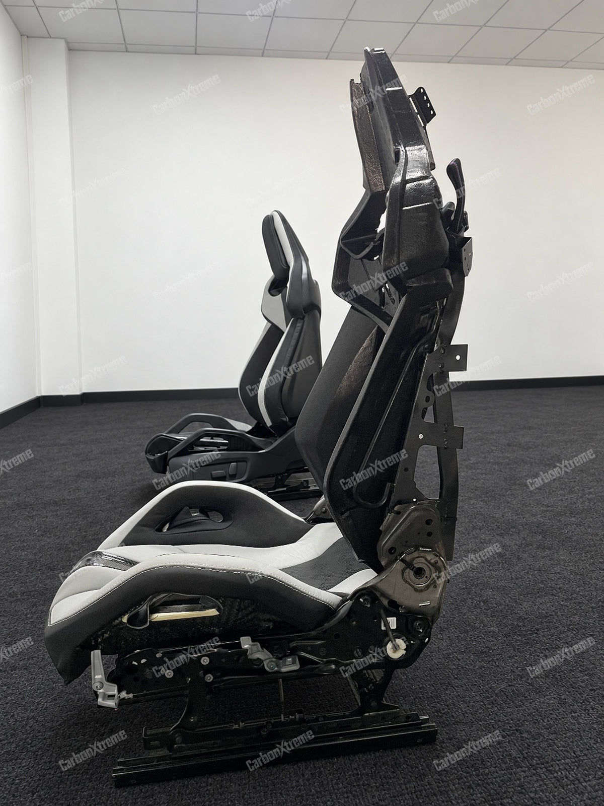 BMW M carbon fiber bucket seat, side profile showing the seat frame, rails and adjustment hardware