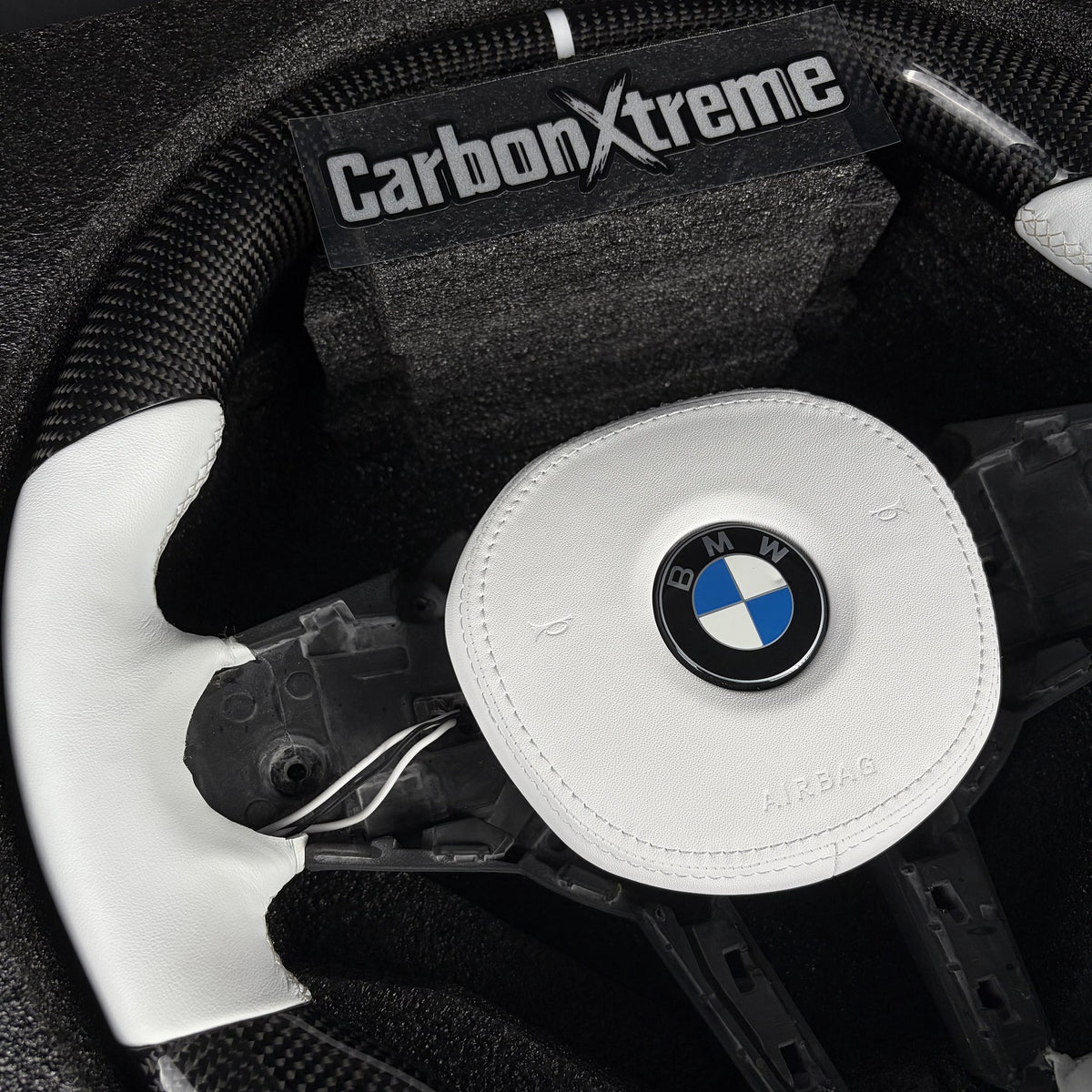 White leather grip and white leather airbag cover on the custom carbon fiber steering wheel