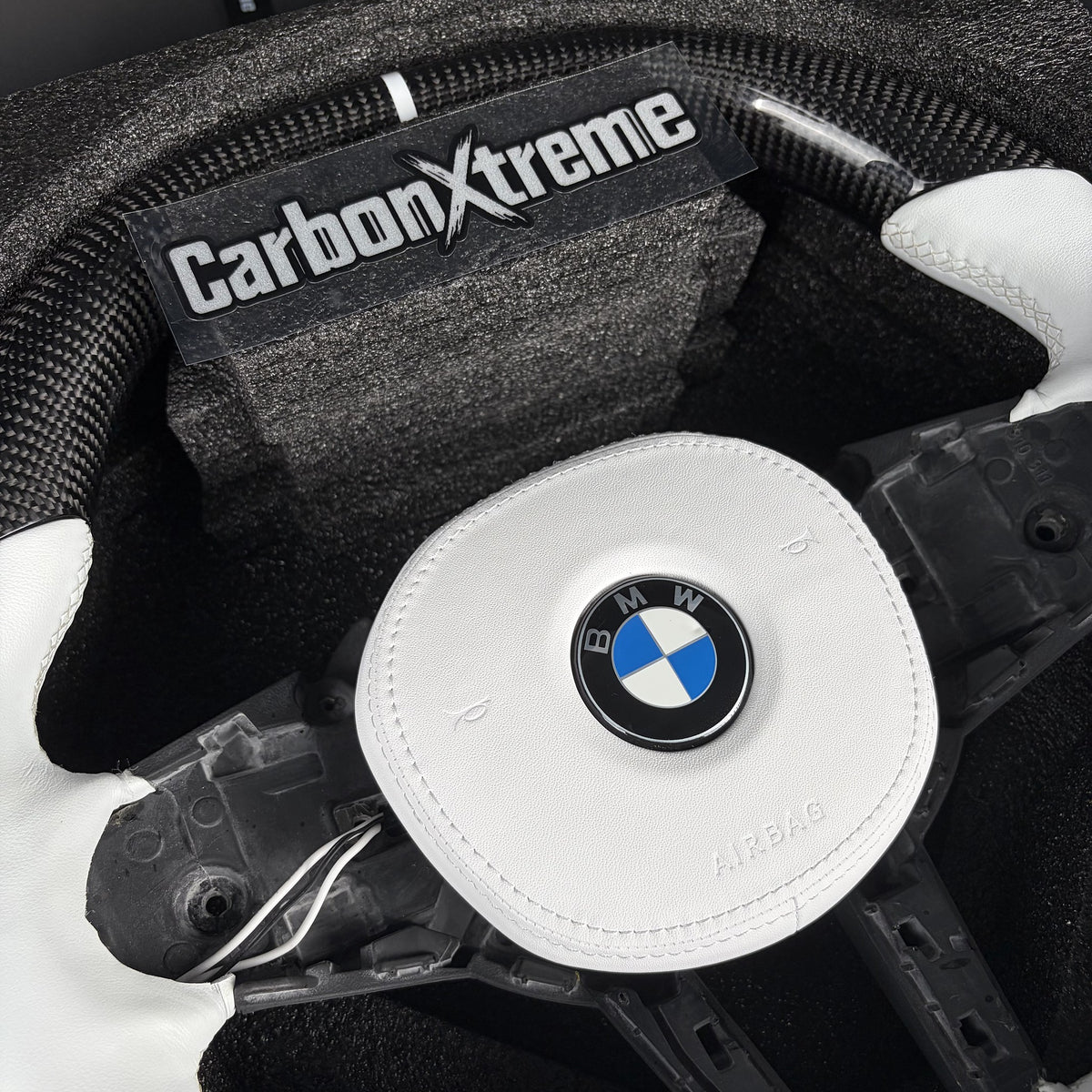 Twill carbon fiber top rim with white 12 o'clock stripe on the custom BMW steering wheel