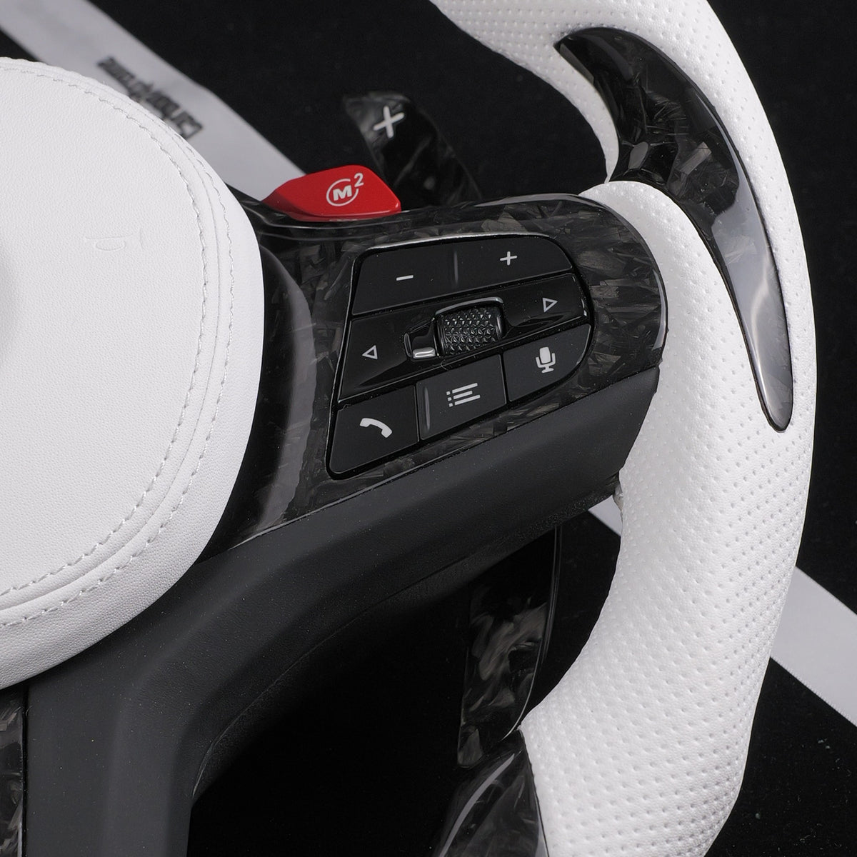 Close-up of the white perforated leather grip and forged carbon fiber spoke trim