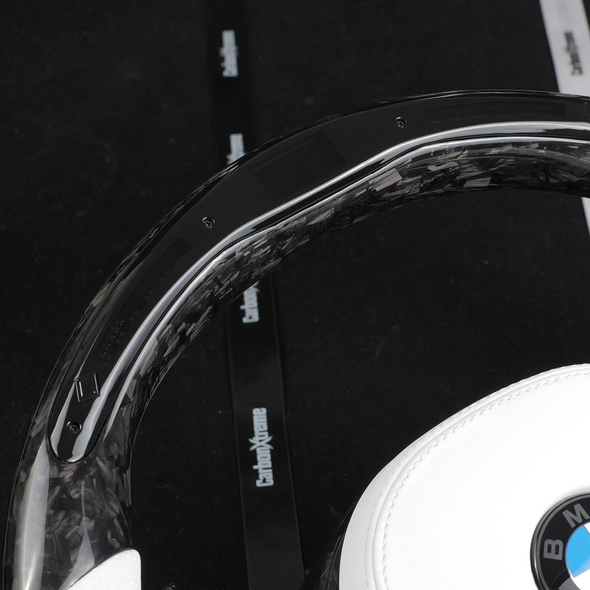 Forged carbon fiber top rim with built-in LED shift light strip on the custom BMW steering wheel