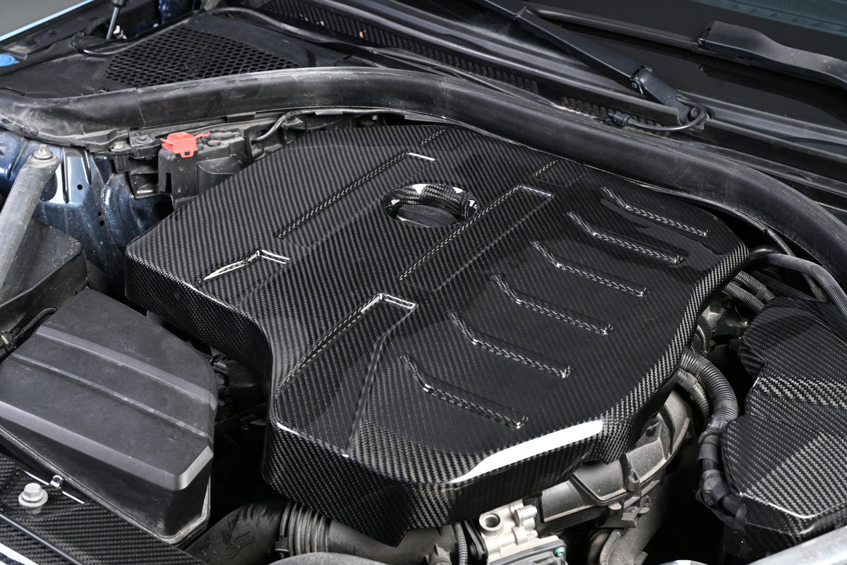 BMW G22 4 Series B48 carbon fiber engine cover is shown installed at an angle, with the oil cap visible.