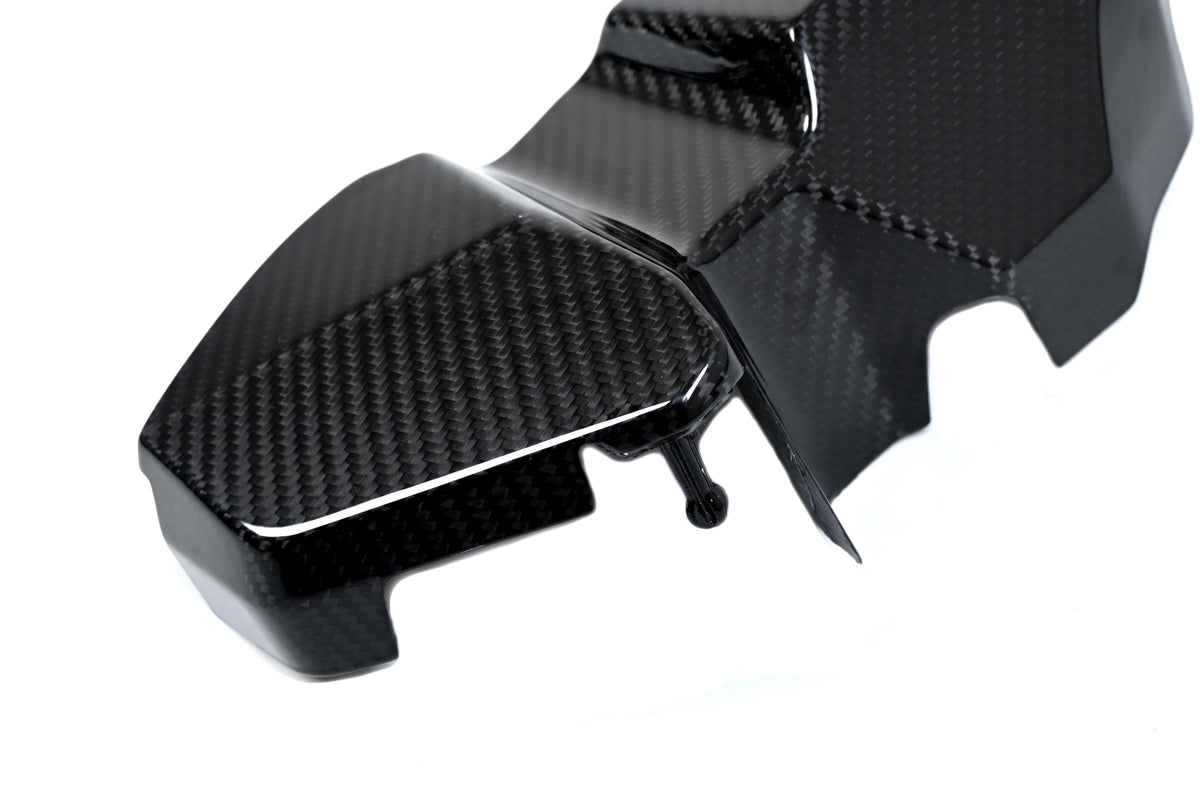 BMW G22 4 Series carbon fiber ECU battery terminal cover is shown close up with its lower lip and small tab.