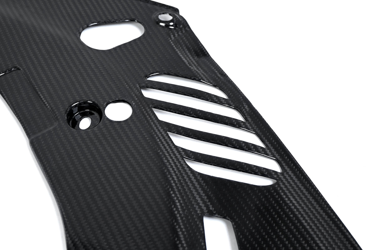 BMW G22 4 Series carbon fiber headlight cover panels are shown close up with round holes beside diagonal slots.