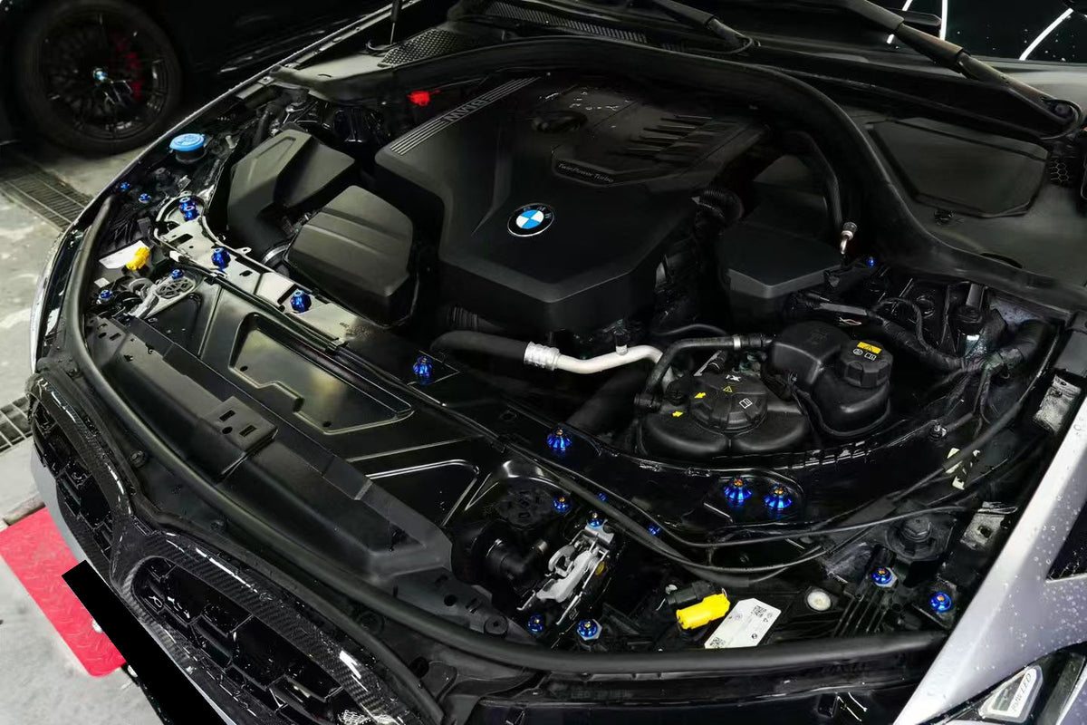 BMW G22 4 Series titanium engine bay bolt kit is seen at an angle with blue heads along the front and right side.