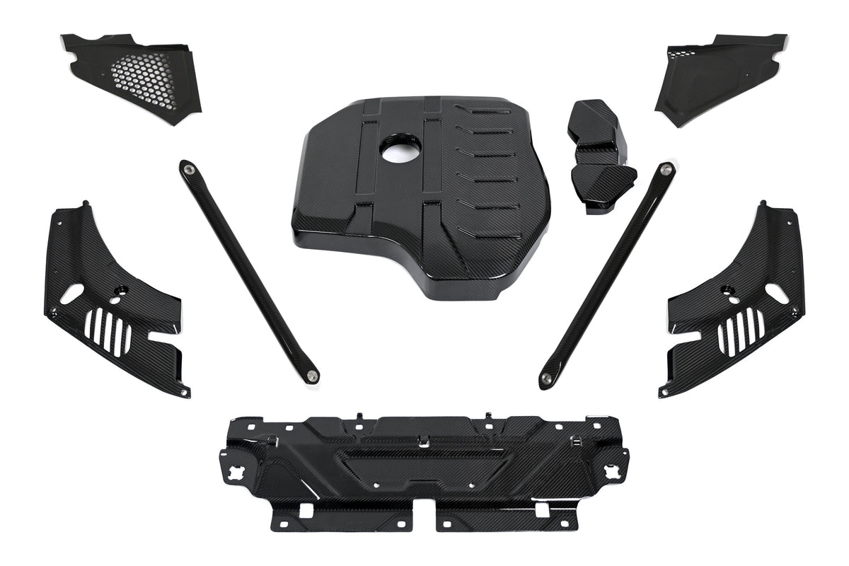 BMW G22 4 Series carbon fiber engine bay kit laid out on white with the engine cover, ECU battery terminal cover, headlight cover panels, corner panels, slam panel cover and strut brace