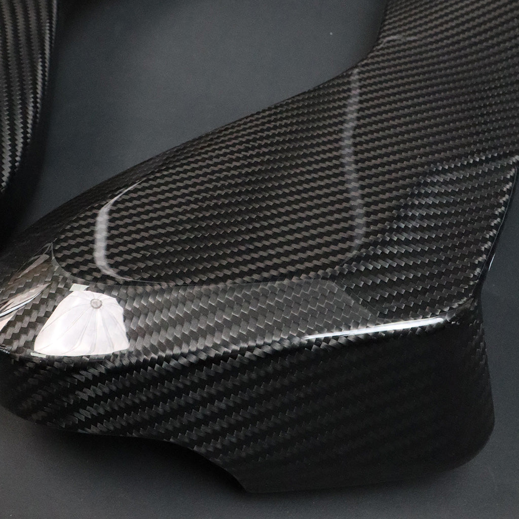 BMW G8X M2 M3 M4 Dry Carbon Side Seat Cover lower panel – carbon weave texture and curved edge close-up, protective film on
