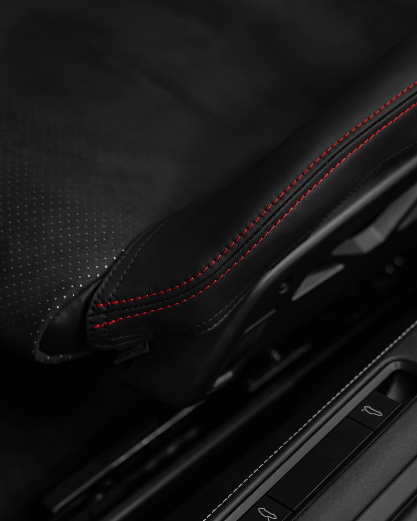 Detail of Porsche 992.2 folding bucket seat bolster protector, perforated black leather red stitching