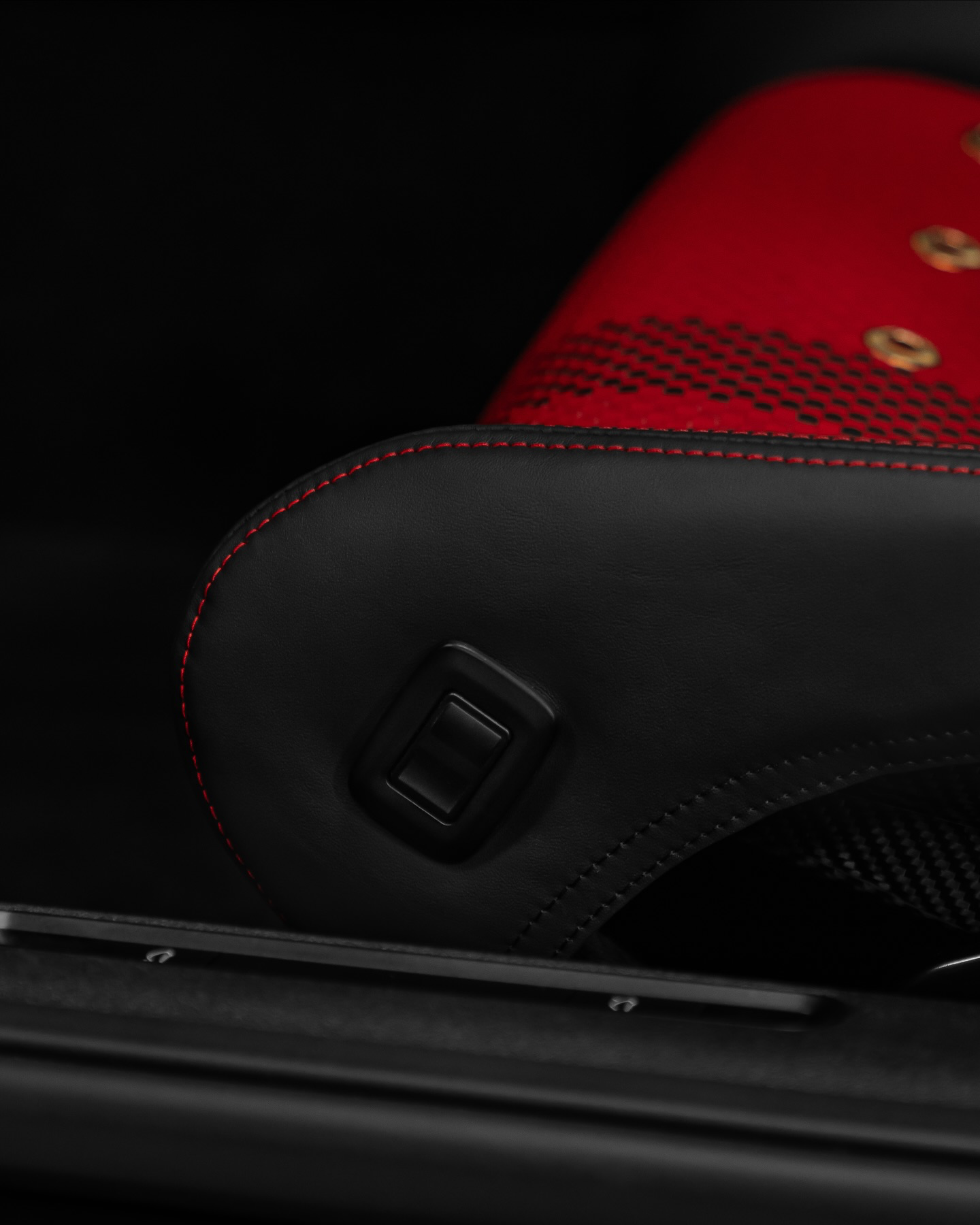 Detail of handmade Porsche bucket seat bolster protector, black leather with red stitching