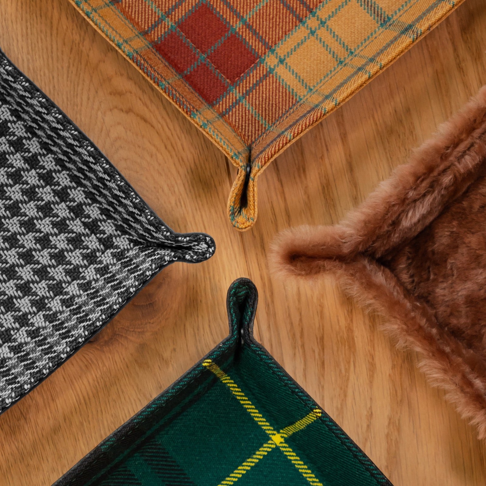 Corner detail of handmade leather valet trays showing the snap fastener and tartan and shearling linings