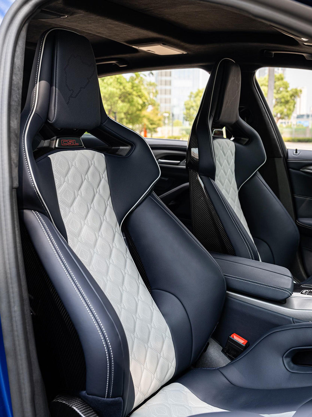 Pair of BMW M5 carbon bucket seats, navy leather with white diamond quilted center stripes, illuminated CSL headrest emblem and Nurburgring outline stitching