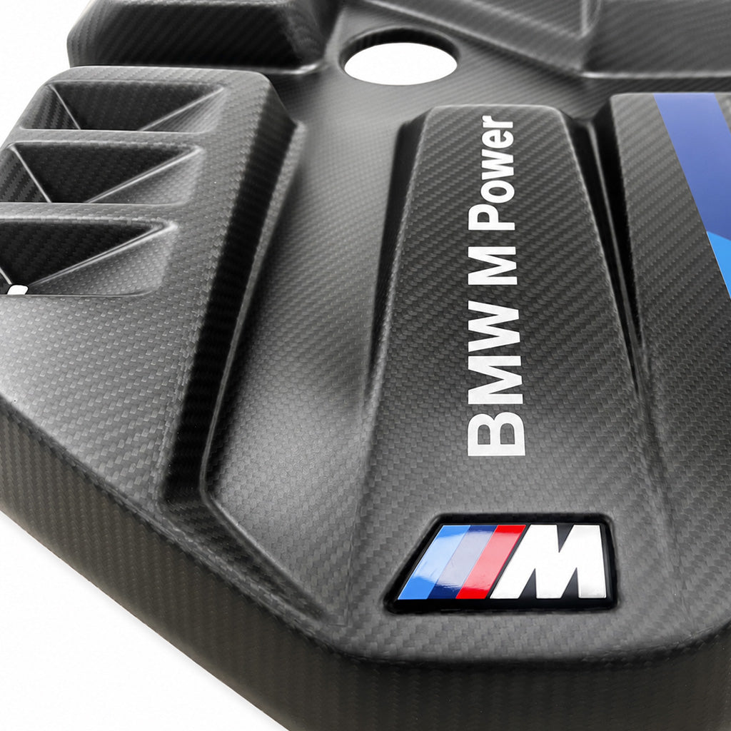 Macro of BMW G8X S58 EVE carbon fiber engine cover, BMW M Power lettering and M badge on the carbon weave