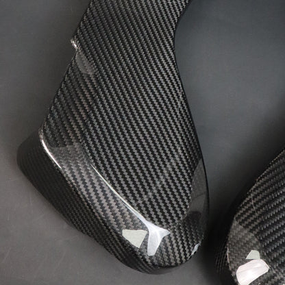 BMW G8X M2 M3 M4 Dry Carbon Side Seat Cover pair gloss texture – dry carbon weave close-up with protective film partially attached, dark grey background