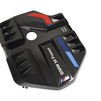 BMW G80 G82 G87 M2 M3 M4 S58 EVE carbon fiber engine cover, three quarter angle showing vented scoops, BMW M Power lettering and carbon weave