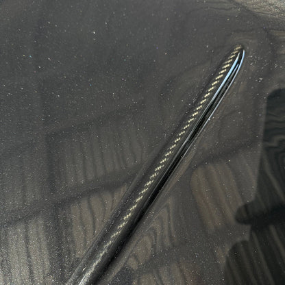 BMW G87 M2 CS carbon fiber trunk lid with a raised character line left in exposed carbon against body paint, a carbon accent line finish