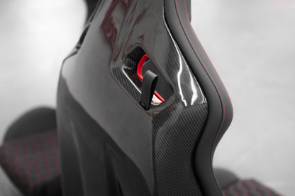 Audi R8 folding bucket seat carbon fiber backrest close-up with leather fold-release strap and red interior detail