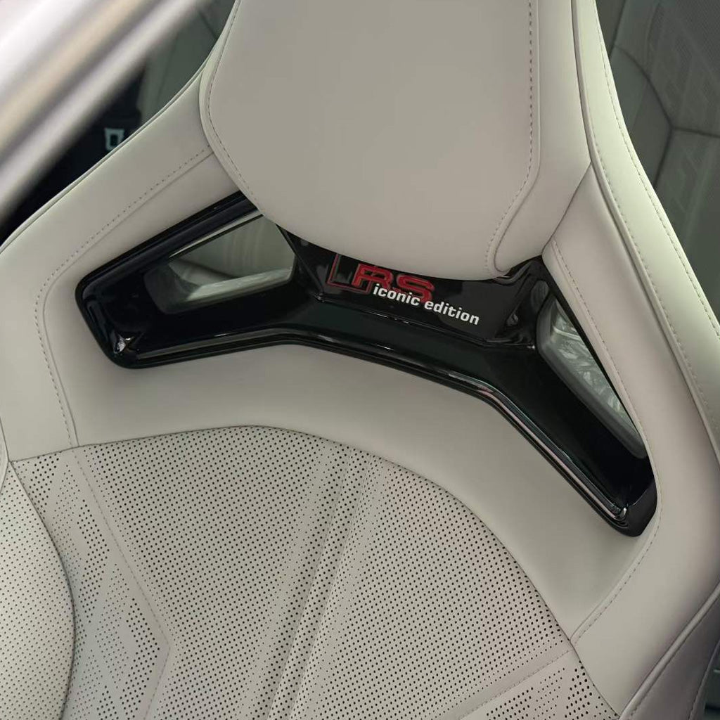 Audi RS bucket seat close-up – RS Iconic Edition headrest trim panel badge detail on white premium upholstery