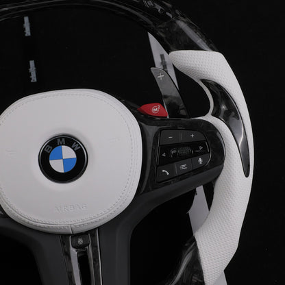 White leather airbag cover, right perforated leather grip, shift paddle and red M2 button on the forged carbon steering wheel
