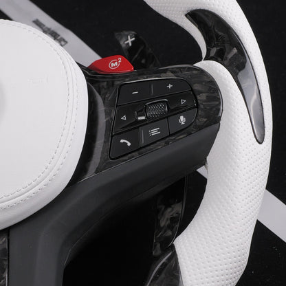 Close-up of the white perforated leather grip and forged carbon fiber spoke trim