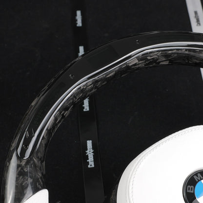 Forged carbon fiber top rim with built-in LED shift light strip on the custom BMW steering wheel