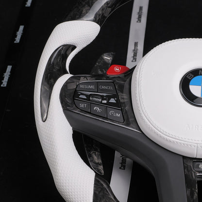 Side view of the white perforated leather grip and shift paddle on the custom forged carbon steering wheel