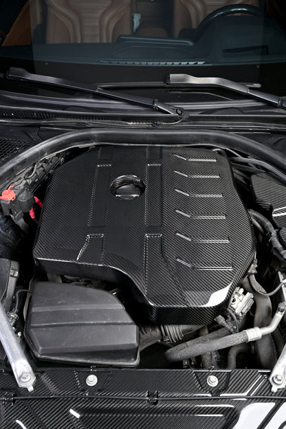 BMW G22 4 Series B48 carbon fiber engine cover is viewed from the front with the windshield visible above it.