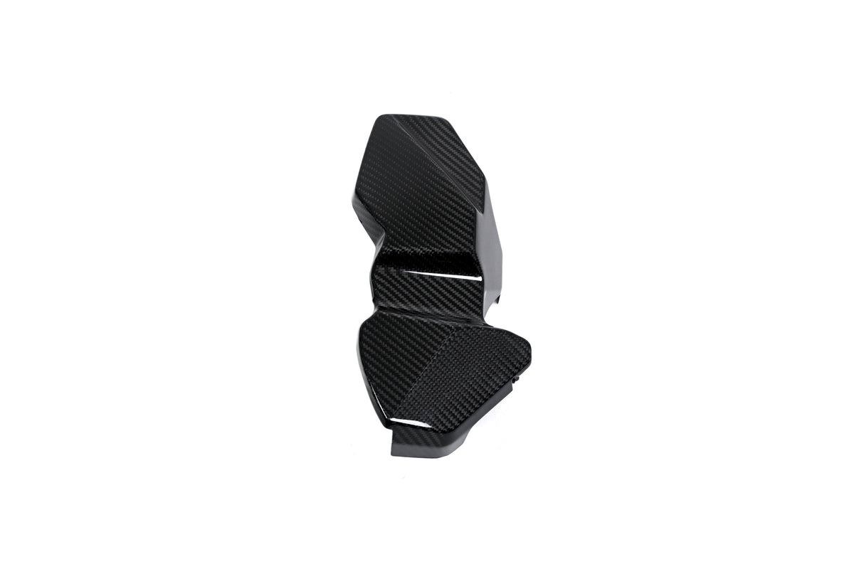 BMW G22 4 Series carbon fiber ECU battery terminal cover is angled on white with its stepped outline visible.