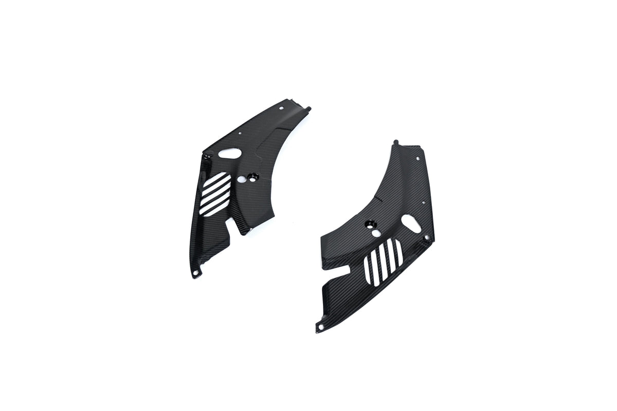 BMW G22 4 Series carbon fiber headlight cover panels sit diagonally on white with the right panel closer.
