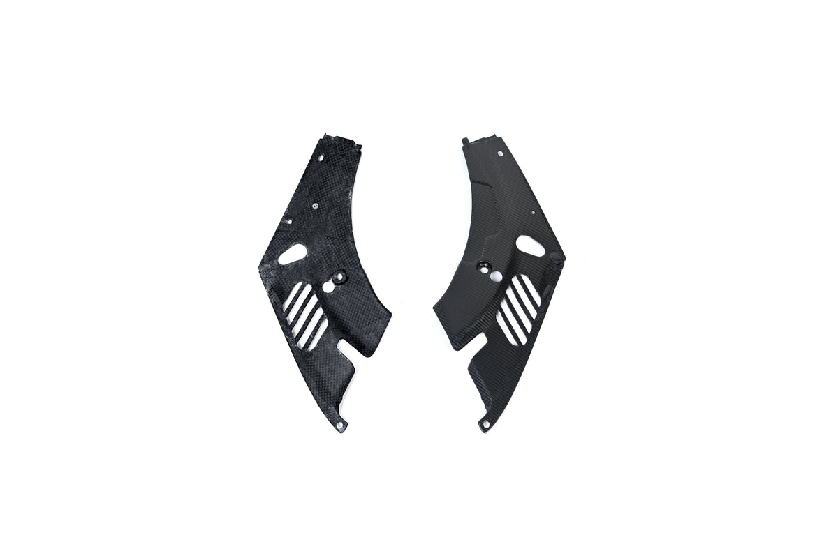 BMW G22 4 Series carbon fiber headlight cover panels are shown on white with one underside facing upward.