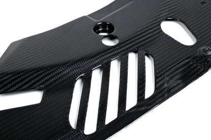 BMW G22 4 Series carbon fiber headlight cover panels are seen close up with tall slots below a recessed hole.