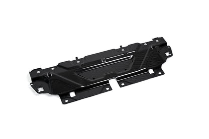 BMW G22 4 Series carbon fiber slam panel cover is angled on white with mounting holes along its front tabs.