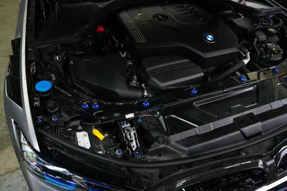 BMW G22 4 Series titanium engine bay bolt kit is shown at an angle with blue heads near the washer fluid cap.