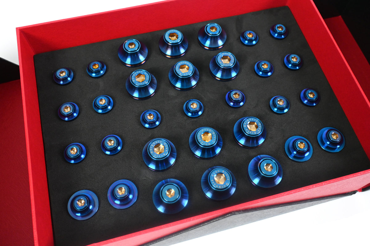BMW G22 4 Series titanium engine bay bolt kit is shown close up with blue heads and gold centers in black foam.