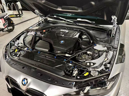 BMW 4 Series engine bay carbon fiber panels are shown in an angled view of a silver car under an open hood.
