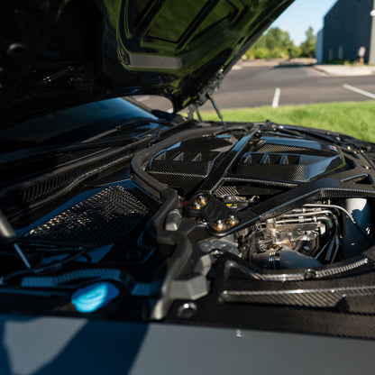 Side detail of the OEM style carbon fiber engine cover and black CSL style strut brace on a BMW G80 M3
