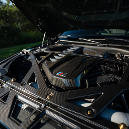 Close-up of the OEM style carbon fiber engine cover and CSL style strut brace on RAG's BMW G80 M3