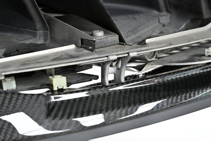 Underside view of the CSL style front lip held by its metal mounting bracket on a BMW G82 M4