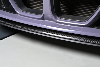 Close-up of the CSL style carbon fiber center lip under a BMW G82 M4 front bumper