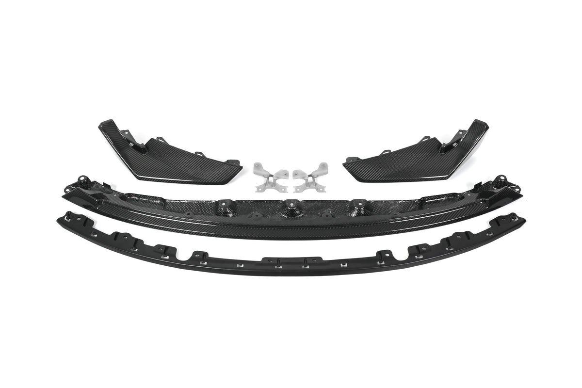 BMW G80 M3 G82 M4 CSL style carbon fiber front lip with corner splitters and metal mounting brackets laid out on white