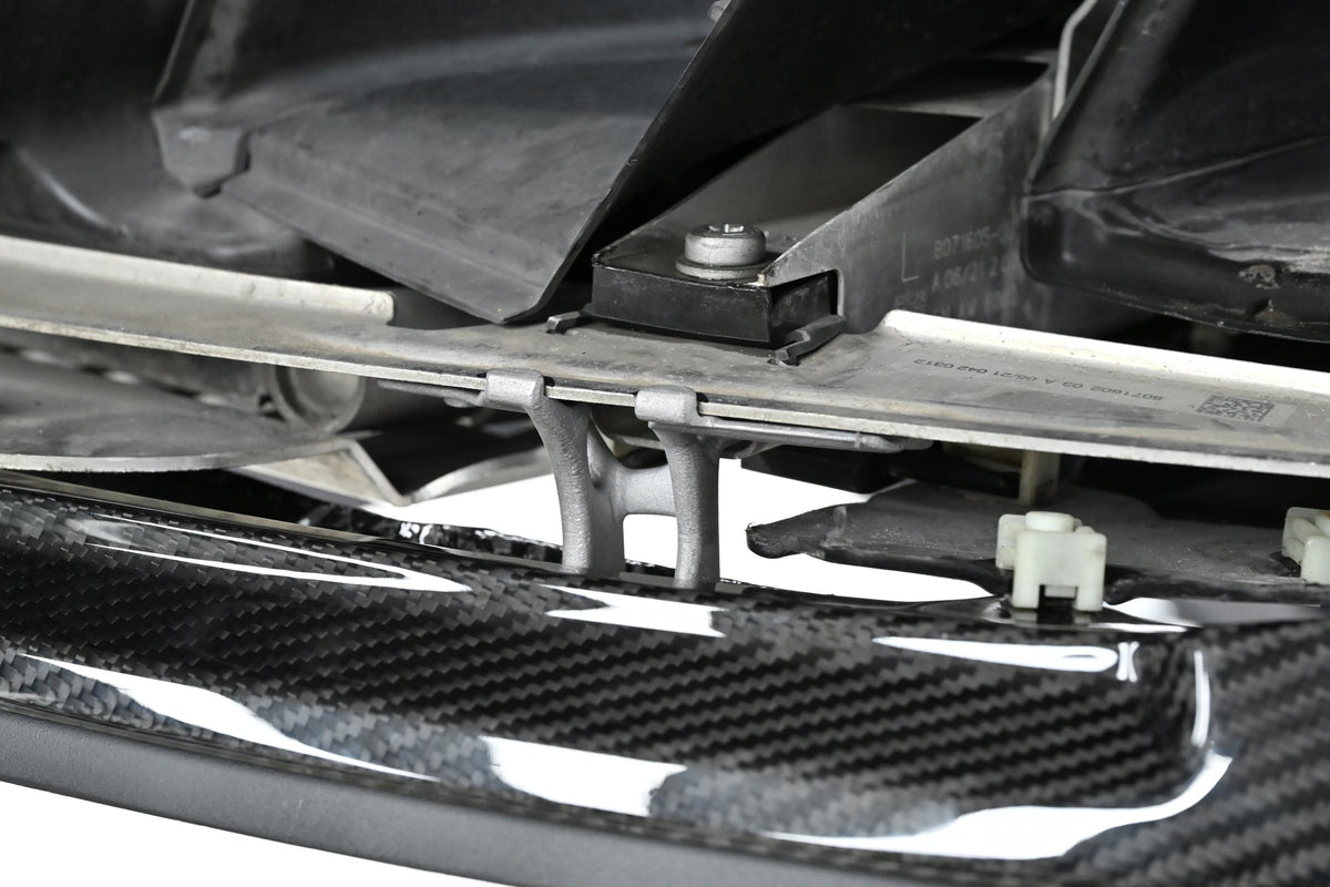 Underside view of the CSL style carbon fiber front lip mounting on a BMW G82 M4