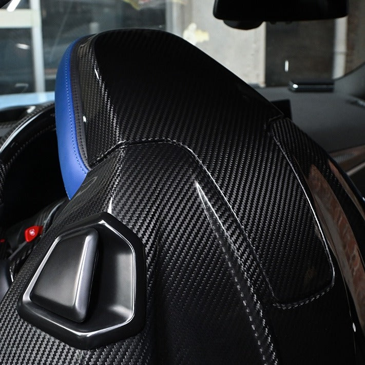 BMW G8X M2 M3 M4 Carbon Fiber Seat Back Replacement installed, upper shell and headrest close up with gloss carbon weave in blue leather interior