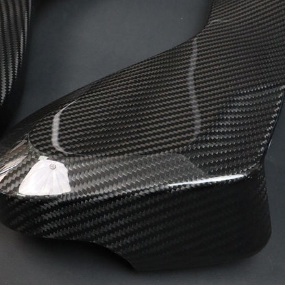 BMW G8X M2 M3 M4 Dry Carbon Side Seat Cover lower panel – carbon weave texture and curved edge close-up, protective film on