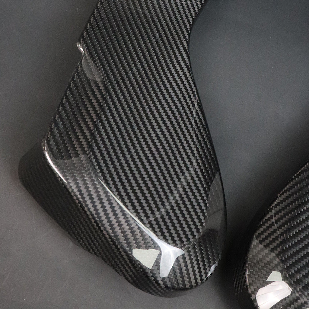 BMW G8X M2 M3 M4 Dry Carbon Side Seat Cover pair texture – dry carbon 2x2 weave close-up, protective film partially attached
