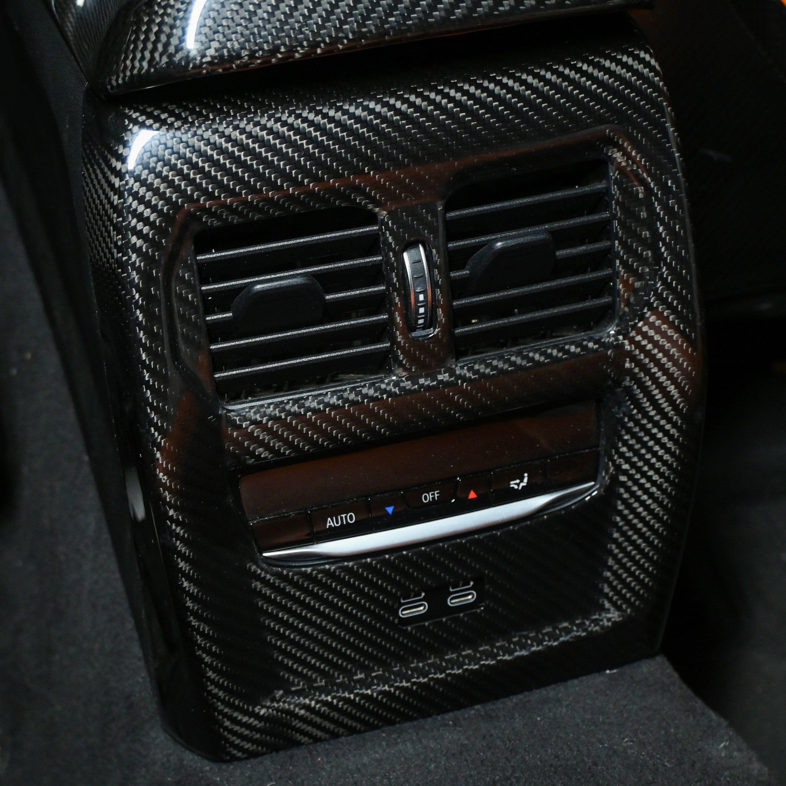 BMW M3 M4 carbon fiber rear vent trim installed, close up with USB C ports below the vents