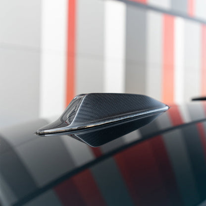 Carbon fiber shark fin antenna cover fitted on the roof of a black BMW M