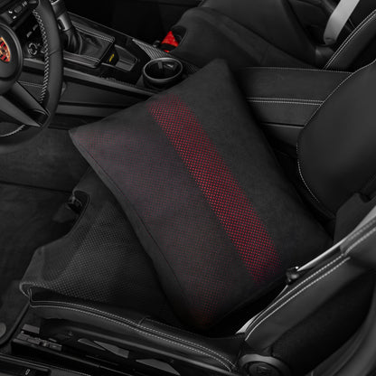 Black Alcantara space increase pillow with red dot perforation seated in the base of a Porsche 992.2 folding carbon bucket seat
