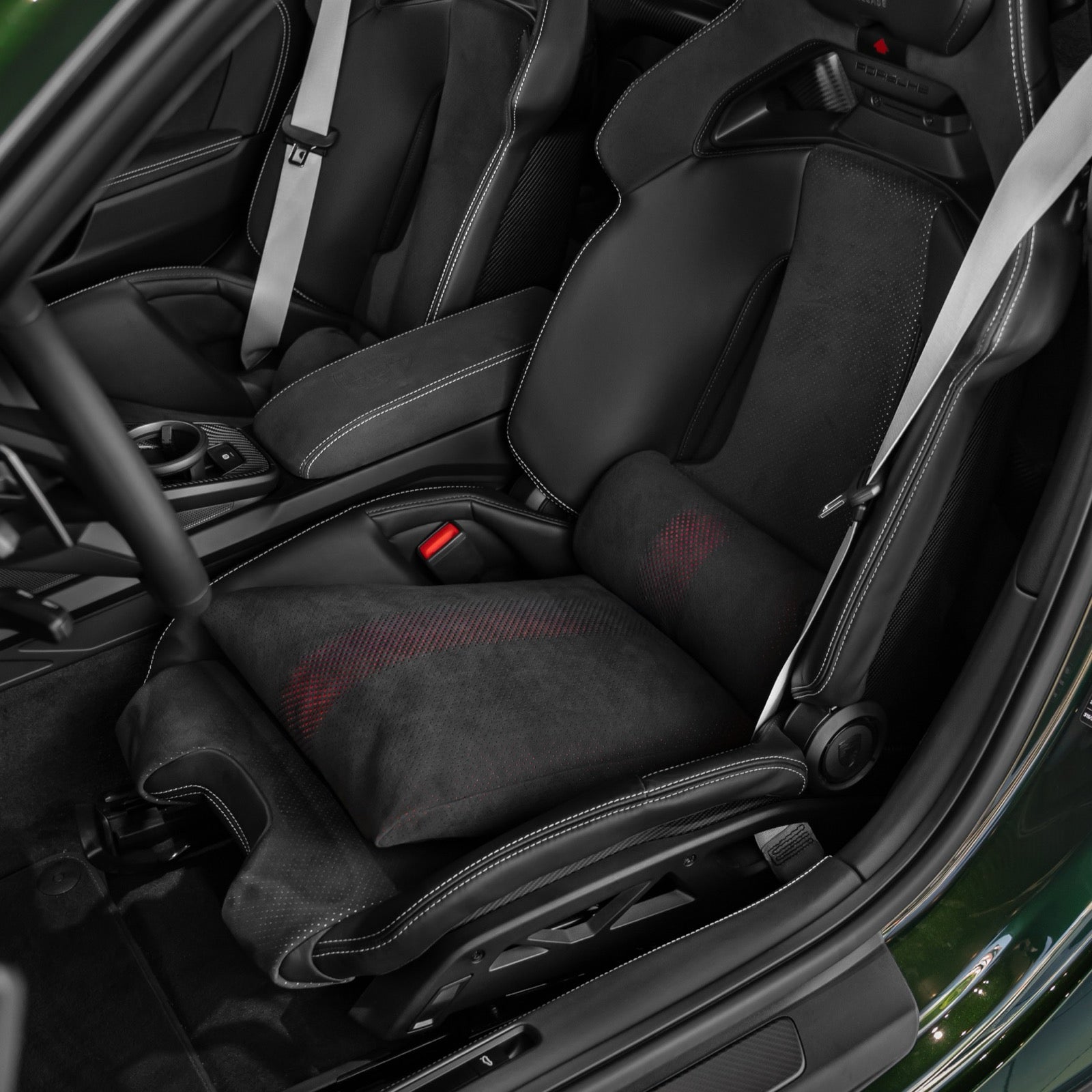 Black Alcantara space increase pillow with red perforated stripe resting in a Porsche 992.2 GT3 folding carbon bucket seat